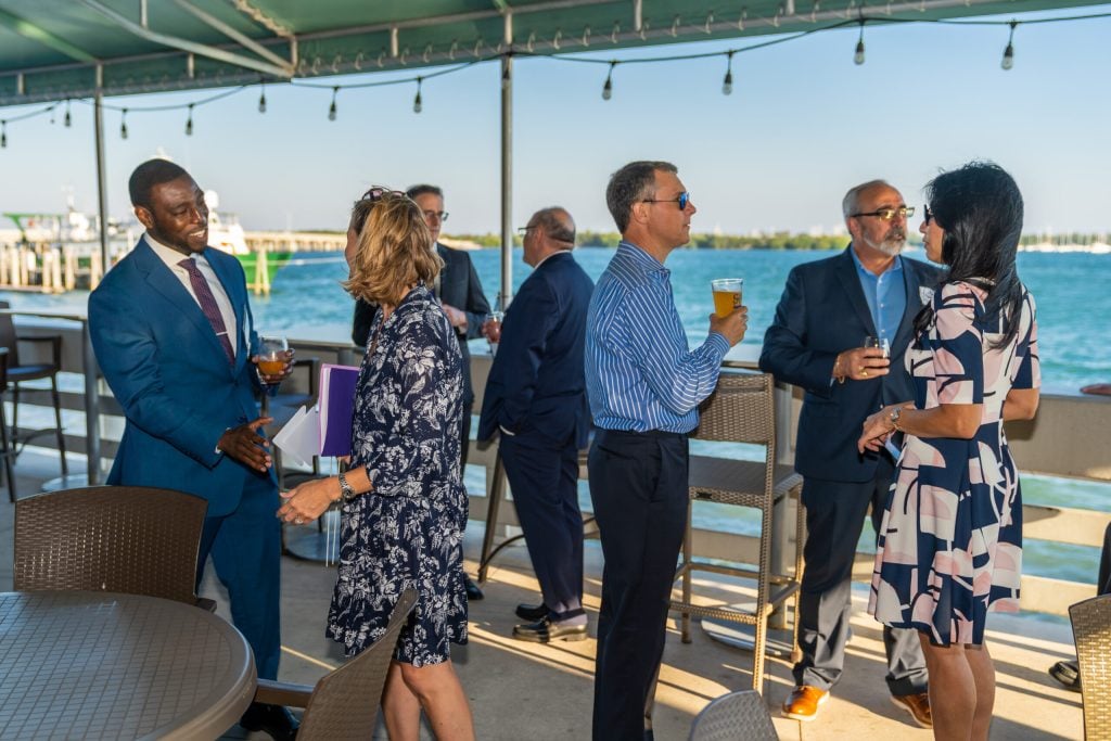 Guests talking on a waterfront terrace at the 2023 Judicial Reception